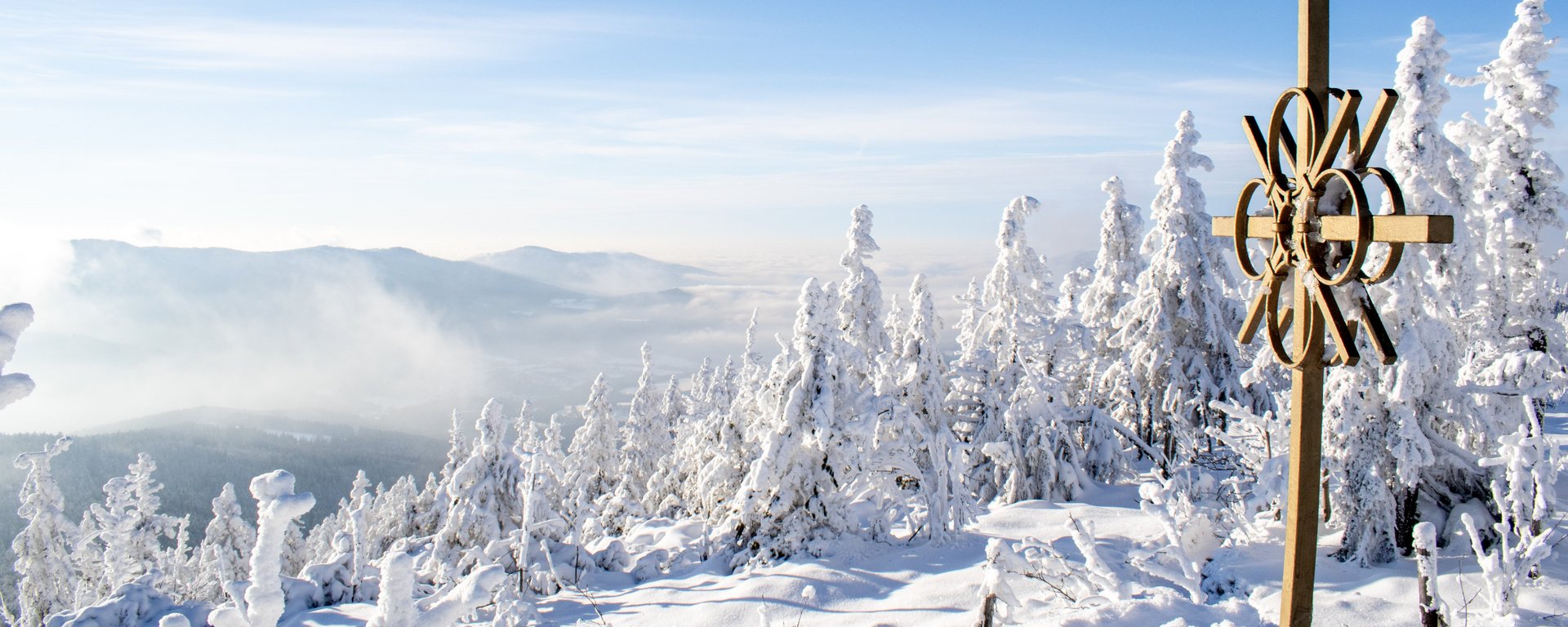 Winterlandschaft mit Sonnenschein und Gipfelkreuz 
