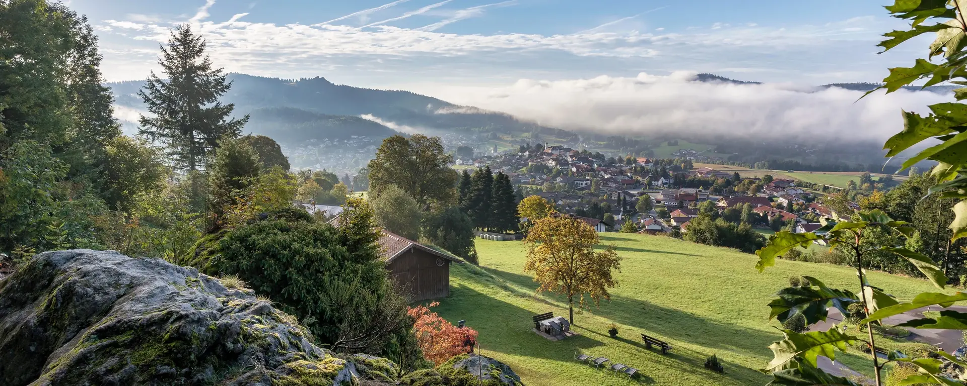 Blick auf den Ortskern Bodenmais der von aufsteigenden Nebel und Wälder umgeben ist   